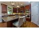 Well-lit kitchen with stainless steel appliances, wooden cabinets, granite countertop, and modern lighting at 141 Olde Heritage Way, Woodstock, GA 30188