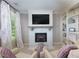 Inviting living room with a white brick fireplace, built-in shelves, and large windows for ample light at 141 Olde Heritage Way, Woodstock, GA 30188