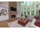 Bright living room featuring a stone fireplace, large windows and comfortable seating at 141 Olde Heritage Way, Woodstock, GA 30188