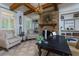 Inviting home office featuring a stone fireplace, wooden beams, built-in shelving and comfortable seating at 141 Olde Heritage Way, Woodstock, GA 30188