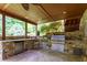 Covered outdoor kitchen with stone countertops, built-in grill, and stainless steel appliances at 141 Olde Heritage Way, Woodstock, GA 30188