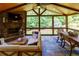 Inviting sunroom with stone fireplace, wood ceiling, exposed beams, and stylish furniture at 141 Olde Heritage Way, Woodstock, GA 30188