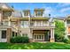 Charming backyard view of the multi-story home with a deck, patio, and lush green landscaping at 2412 St Davids Sq # 16, Kennesaw, GA 30152