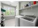 Bright laundry room with tile floor, washer, dryer and shelving at 2412 St Davids Sq # 16, Kennesaw, GA 30152