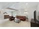Cozy basement living room with comfortable leather sofas, a coffee table, and a TV, perfect for relaxation at 3841 Admiral Dr, Atlanta, GA 30341