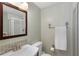 Charming bathroom featuring a mosaic-tiled sink, toilet, and shower with glass doors, creating a clean and functional space at 3841 Admiral Dr, Atlanta, GA 30341
