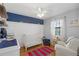 Bedroom with a navy accent wall, wood floor, white crib, and comfortable white chair at 3841 Admiral Dr, Atlanta, GA 30341