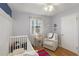 Bright Bedroom with wood floor, a cozy white chair, and a white crib at 3841 Admiral Dr, Atlanta, GA 30341
