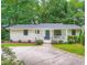 Charming single-story home with a blue front door, white trim, and lush green landscaping at 3841 Admiral Dr, Atlanta, GA 30341