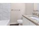This bathroom features a granite countertop, a white cabinet, and stylish marble tiling in the shower/tub area at 793 Springdale Sw, Atlanta, GA 30315