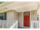 Exterior view of a home entrance, featuring a red front door, a shingled facade, and simple decorative lighting at 793 Springdale Sw, Atlanta, GA 30315