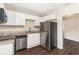 Bright kitchen with stainless steel appliances, granite counters, white cabinets, and dark hardwood floors at 793 Springdale Sw, Atlanta, GA 30315