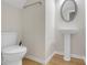Powder room with pedestal sink, oval mirror and wood look flooring and white walls at 1804 Evadale Ct # 1, Mableton, GA 30126