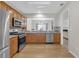 Modern kitchen with stainless steel appliances, wooden cabinets, and a view to the living area at 1804 Evadale Ct # 1, Mableton, GA 30126