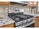 Close-up of stainless steel oven with range hood and granite countertops with light brown cabinetry at 1804 Evadale Ct # 1, Mableton, GA 30126