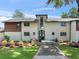 Charming home featuring a manicured lawn, blooming flowers, and a welcoming walkway at 2775 Club Valley Ct, Jonesboro, GA 30236