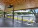 Spacious covered patio featuring a scenic water view and a wooden paneled ceiling with ceiling fan at 2775 Club Valley Ct, Jonesboro, GA 30236