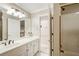 Well-lit bathroom featuring a white vanity, sink, and a shower with glass doors at 2885 Coles Way, Atlanta, GA 30350