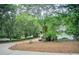 View of a circular driveway surrounded by trees, leading to an elegant home in the distance at 2885 Coles Way, Atlanta, GA 30350