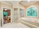 Main bathroom with a jetted tub, stand-up shower, and an arched stained glass window at 2885 Coles Way, Atlanta, GA 30350