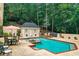 Backyard pool area featuring a cozy pool house and outdoor seating surrounded by mature trees and greenery at 2885 Coles Way, Atlanta, GA 30350