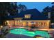 Night view of pool with illuminated water, patio seating, and landscaped backyard for evening relaxation and entertainment at 2885 Coles Way, Atlanta, GA 30350