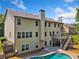 Back exterior of a two-story home showcasing a swimming pool, deck, and ample yard space at 1344 Hamilton Creek Nw Dr, Kennesaw, GA 30152