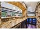 Spacious basement bar featuring stone accents, granite countertops, and a built-in beverage fridge at 1344 Hamilton Creek Nw Dr, Kennesaw, GA 30152