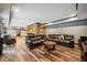 Open basement living area with wood floors, a stone wall, and a comfortable leather sectional at 1344 Hamilton Creek Nw Dr, Kennesaw, GA 30152