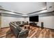 Basement living area with a wall mounted TV and leather sofa on wood look flooring at 1344 Hamilton Creek Nw Dr, Kennesaw, GA 30152