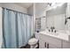 Bright bathroom featuring a white vanity, sleek black hardware, and a shower with a blue curtain at 1344 Hamilton Creek Nw Dr, Kennesaw, GA 30152