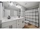 Bright bathroom featuring double vanity sinks, modern black hardware, and a tiled shower at 1344 Hamilton Creek Nw Dr, Kennesaw, GA 30152