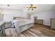 Primary bedroom with hardwood flooring, large bed, dresser, and bright lighting at 1344 Hamilton Creek Nw Dr, Kennesaw, GA 30152