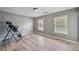 Empty bedroom with light hardwood flooring and two windows providing natural light at 1344 Hamilton Creek Nw Dr, Kennesaw, GA 30152