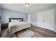 This bedroom features hardwood floors, a queen bed with white bedding, and a closet at 1344 Hamilton Creek Nw Dr, Kennesaw, GA 30152