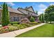 Inviting two-story home with a stone facade, lush landscaping, and a well-maintained lawn at 1344 Hamilton Creek Nw Dr, Kennesaw, GA 30152