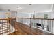 Hallway with hardwood floors and decorative wrought iron banister overlooking the living room at 1344 Hamilton Creek Nw Dr, Kennesaw, GA 30152