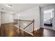 Hallway featuring dark wood floors, decorative railing and open access to a bedroom at 1344 Hamilton Creek Nw Dr, Kennesaw, GA 30152