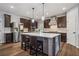 Well-lit kitchen featuring a center island, stainless steel refrigerator, and dark wood cabinets at 1344 Hamilton Creek Nw Dr, Kennesaw, GA 30152