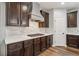 Kitchen with stainless steel appliances and gas cooktop against white backsplash and dark wood cabinets at 1344 Hamilton Creek Nw Dr, Kennesaw, GA 30152