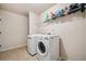 A laundry room featuring modern side-by-side washer and dryer units with tile floor at 1344 Hamilton Creek Nw Dr, Kennesaw, GA 30152
