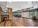 Open living area featuring a stone bar, hardwood floors, and windows that brings in natural light at 1344 Hamilton Creek Nw Dr, Kennesaw, GA 30152