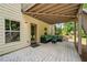 Covered stone patio with comfortable seating, ideal for relaxing and enjoying the outdoor space at 1344 Hamilton Creek Nw Dr, Kennesaw, GA 30152