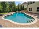 Beautiful in-ground pool with a waterfall feature, surrounded by a patio and lush landscaping at 1344 Hamilton Creek Nw Dr, Kennesaw, GA 30152