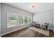 Bright sitting room featuring a trio of windows, hardwood floors, and decorative chairs at 1344 Hamilton Creek Nw Dr, Kennesaw, GA 30152