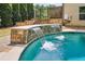 Close-up of pool waterfall feature with decorative stone, adding a touch of luxury and tranquility to the outdoor space at 1344 Hamilton Creek Nw Dr, Kennesaw, GA 30152