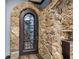 Stunning wine cellar door with ornate metal detailing and rustic stone surround, adding elegance and charm at 1344 Hamilton Creek Nw Dr, Kennesaw, GA 30152