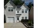 Charming two-story home featuring a one-car garage, lush landscaping, and a welcoming front entrance at 443 Marsh Lake Rd, Lawrenceville, GA 30045