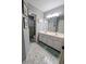 Well-lit bathroom with a double sink vanity, decorative accents, and stylish hexagon tile flooring at 1581 Shetland Pony Ct, Suwanee, GA 30024