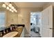 Elegant bathroom showcasing a double vanity with stone countertops and a doorway to the Primary bedroom at 285 Centennial Olympic Park Nw Dr # 1905, Atlanta, GA 30339
